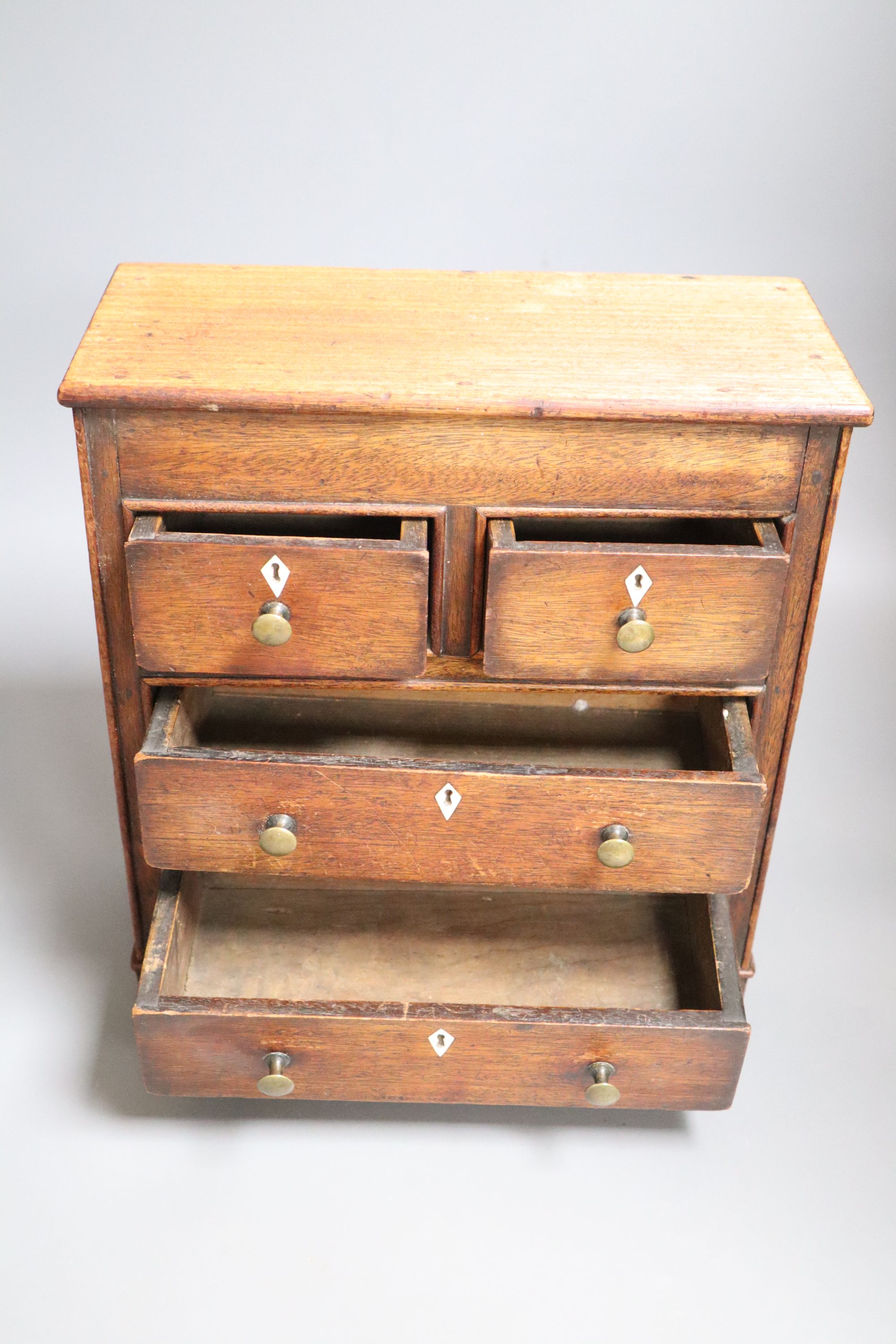 A miniature mahogany chest of drawers, height 33cm